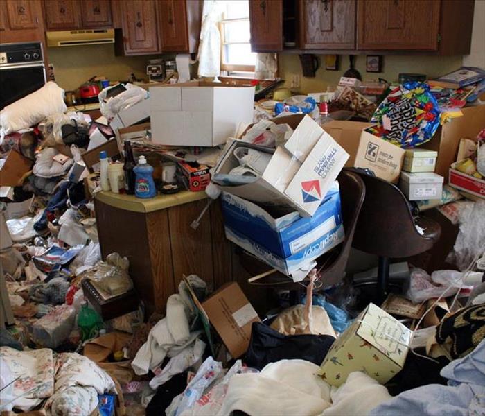 Hoarding mess inside of a house showing trash and boxes and other miscellaneous items scattered around