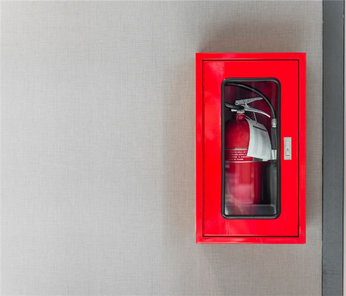 white wall with a red box holding a fire extinguisher